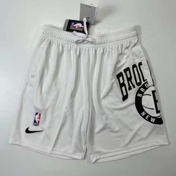 White basketball shorts with Brooklyn Nets branding on the right leg, NBA logo on the left, and a Nike swoosh; tags attached.