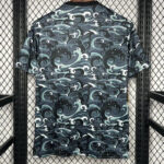Back view of a short-sleeve shirt with a dark blue teal wave pattern covering the entire fabric.