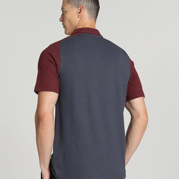 Back view of a man wearing a color-block polo shirt: dark blue torso with maroon sleeves and collar.