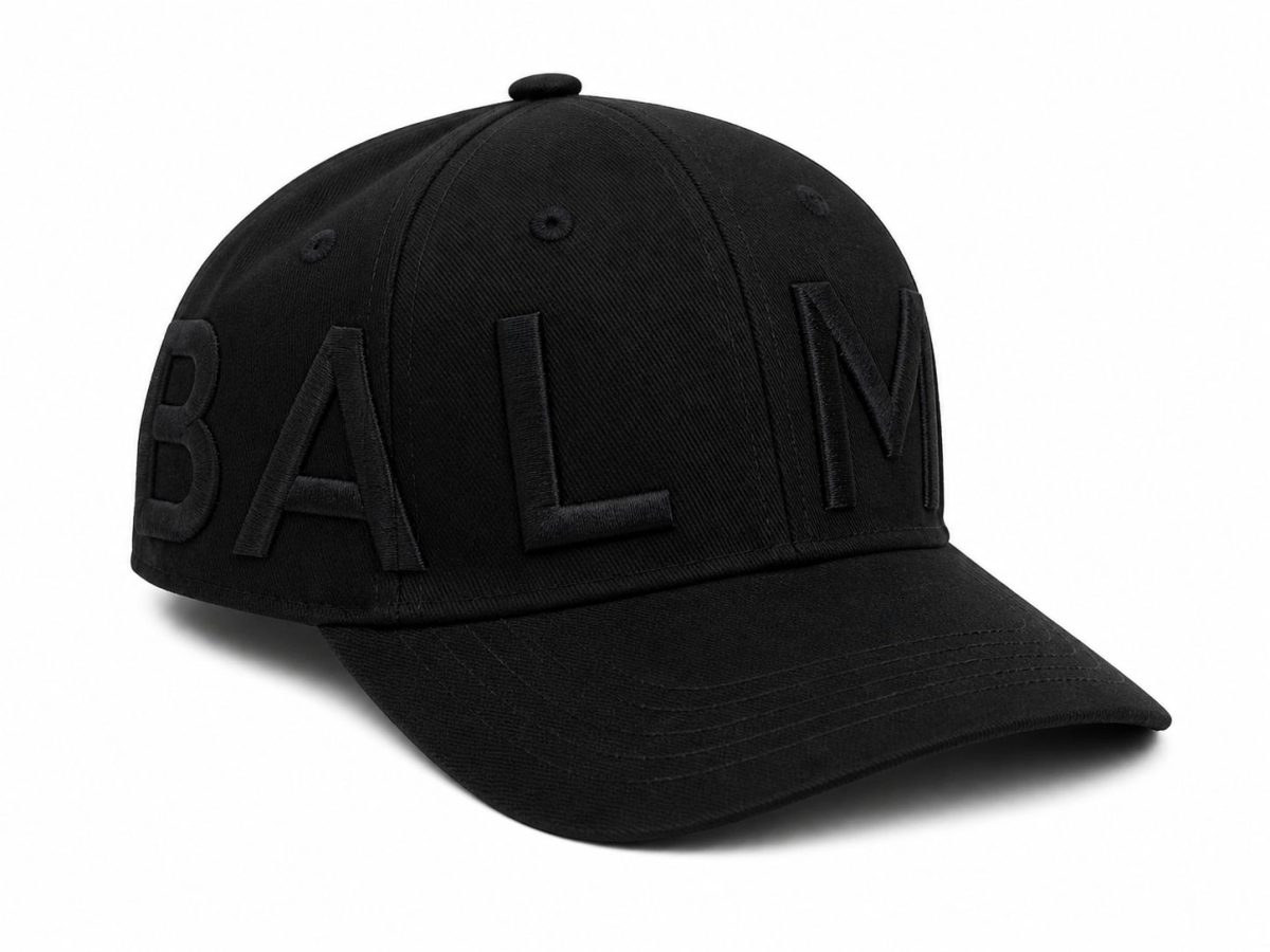 Black baseball cap with large, raised embroidered letters spelling BALM along the side of the crown.