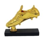 Gold trophy shaped like a soccer cleat mounted on a black base pedestal.