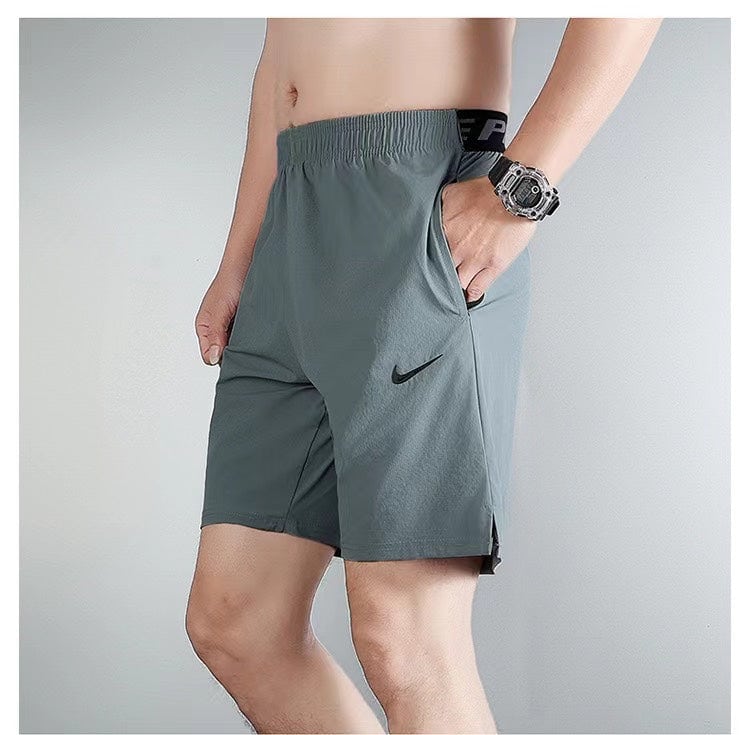 523739ac | UAE SPORT STORE Man wearing gray Nike athletic shorts with pocket, standing in profile with watch visible on wrist.