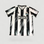 Newcastle United replica football jersey with black-and-white vertical stripes and sponsor 'isela' on the chest, crest visible.