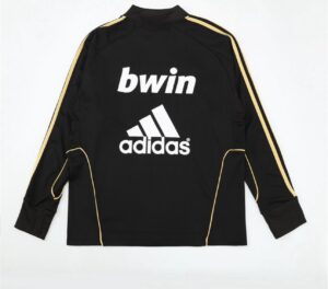 Black athletic jacket with gold stripe piping along sleeves, featuring white Adidas logo and 'bwin' text on the back