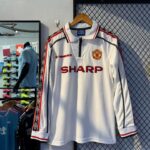 539631012_814088064298042_6683516238870809059_n | UAE SPORT STORE Manchester United white long-sleeve jersey with red sponsor SHARP and club crest on display.