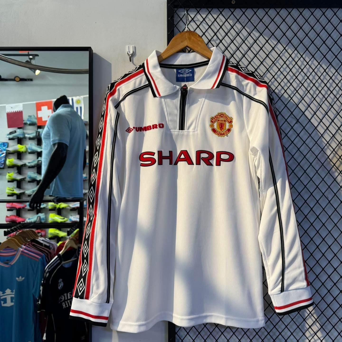 539631012_814088064298042_6683516238870809059_n | UAE SPORT STORE Manchester United white long-sleeve jersey with red sponsor SHARP and club crest on display.