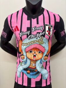 Bright pink and black striped jersey with a large Tony Tony Chopper cartoon and the Japan Football Association patch at chest level.