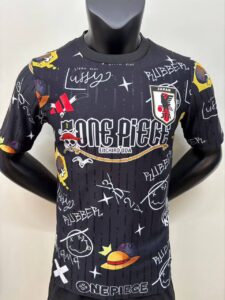 Black graphic T-shirt with One Piece design, signature doodles, straw hat icon, and JFA Japan logo.