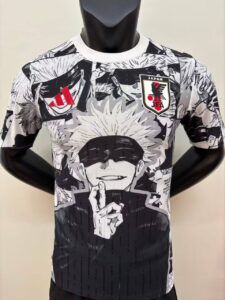 Black-and-white manga-print T-shirt on a mannequin, featuring a character with a blindfold and white hair, and a Japan JFA crest on the chest.