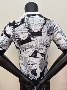 Back view of a white shirt covered in black-and-white manga panels, worn on a mannequin with arms behind.