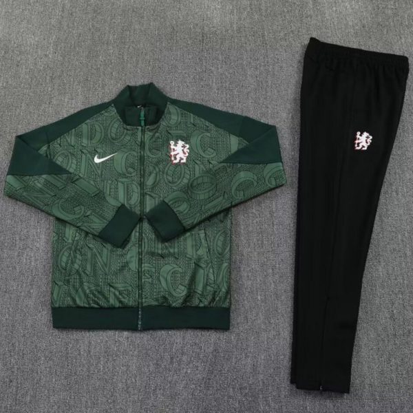 Green training tracksuit jacket with an abstract pattern, white Nike swoosh on the chest, and a red‑outlined Dutch lion crest; paired with black athletic pants featuring the same crest.