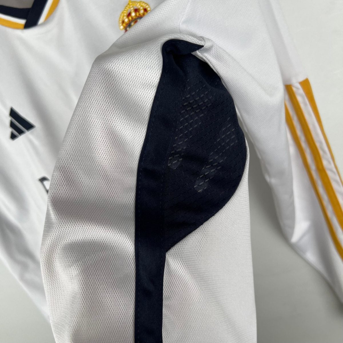 Close-up of white mesh fabric with a dark vertical stripe and hints of yellow trim on the side.