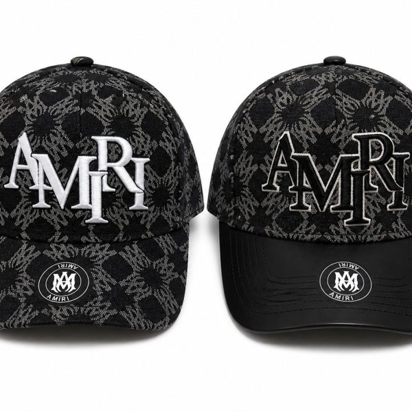 Two black caps with a gray jacquard pattern and AMIRI branding, one with solid white 'AMIRI' embroidery and the other with outlined embroidery on the front panels.