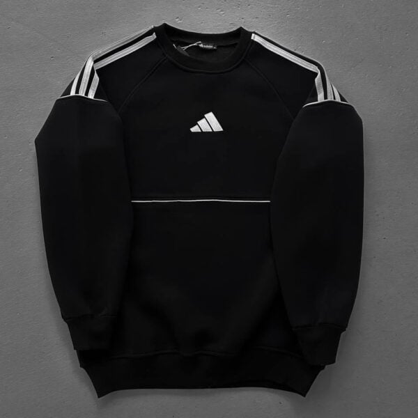 Black Adidas sweatshirt with white stripes on shoulders and logo, laid flat on a gray background.