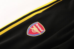 Arsenal club crest embroidered on black fabric with yellow trim.