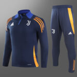 Juventus navy training tracksuit: long-sleeve top with blue zipper and orange shoulder stripes, matching pants with orange side stripe and logos near chest and thigh.