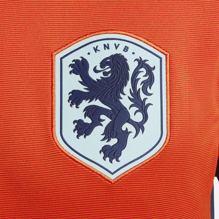 57682577_2836_4095_ba92_90eeb06fb5a2 | UAE SPORT STORE Orange fabric with a light blue shield patch showing a dark blue rampant lion and the letters KNVB at the top, a Netherlands football crest.