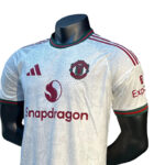 576aa136-9cf2-4b17-9531-9e80fd756532 | UAE SPORT STORE White Manchester United soccer jersey on a mannequin with Snapdragon sponsor logo and club crest visible on the chest.