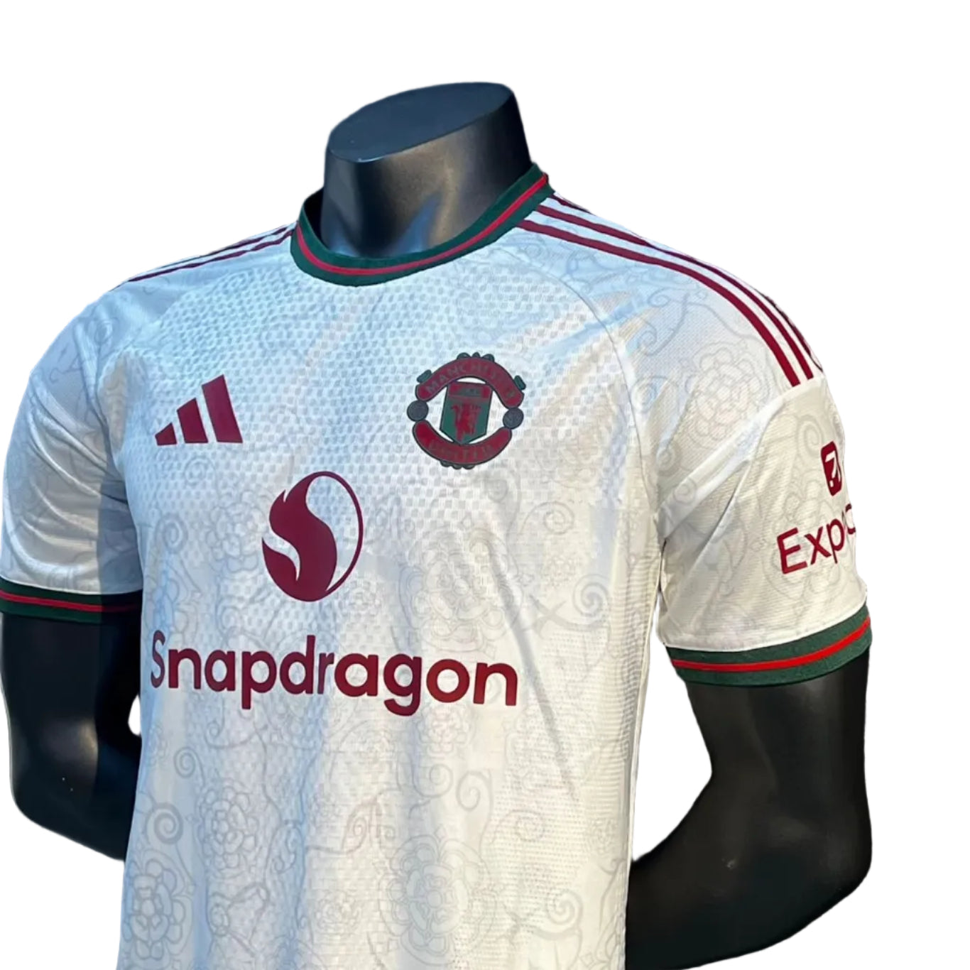 576aa136-9cf2-4b17-9531-9e80fd756532 | UAE SPORT STORE White Manchester United soccer jersey on a mannequin with Snapdragon sponsor logo and club crest visible on the chest.