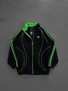 Black Adidas track jacket with neon green piping and front zipper, chest logo visible.