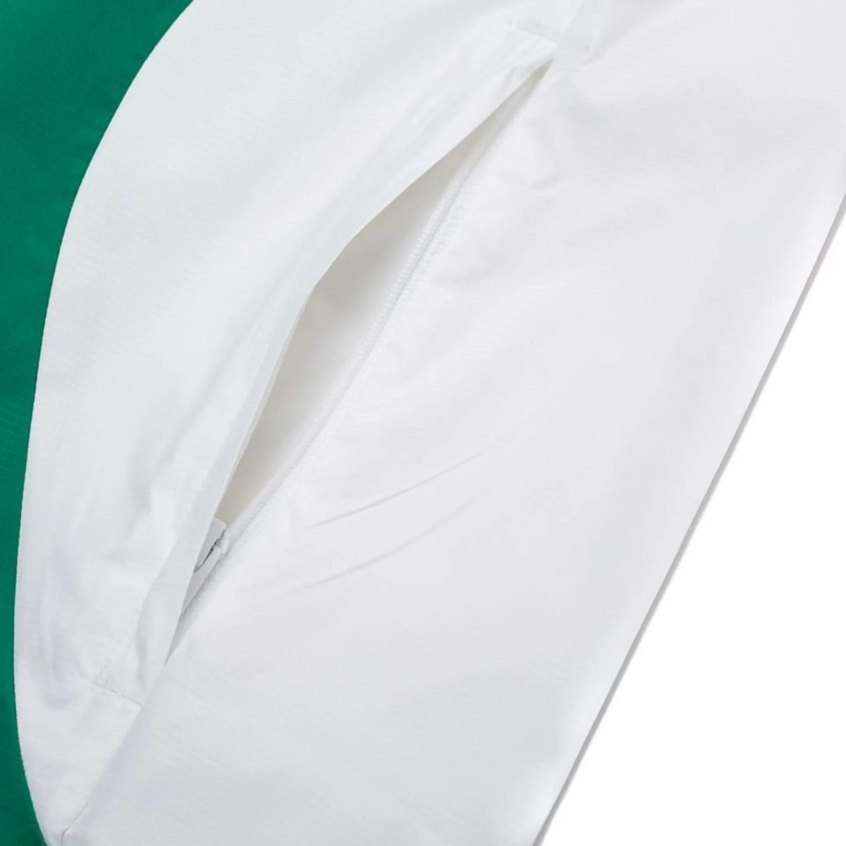 Close-up of a white fabric or bag with a bold vertical green edge on the left, showing a seam or fold in the material.