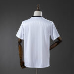 Back view of a white short-sleeve polo shirt with subtle vertical stripes on a mannequin against a dark background, showing the garment's fit and collar detail.