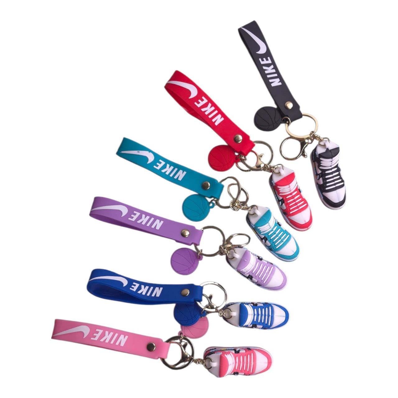 5805548633519671565 | UAE SPORT STORE Multiple colorful Nike sneaker keychains attached to colored lanyards on a white background.
