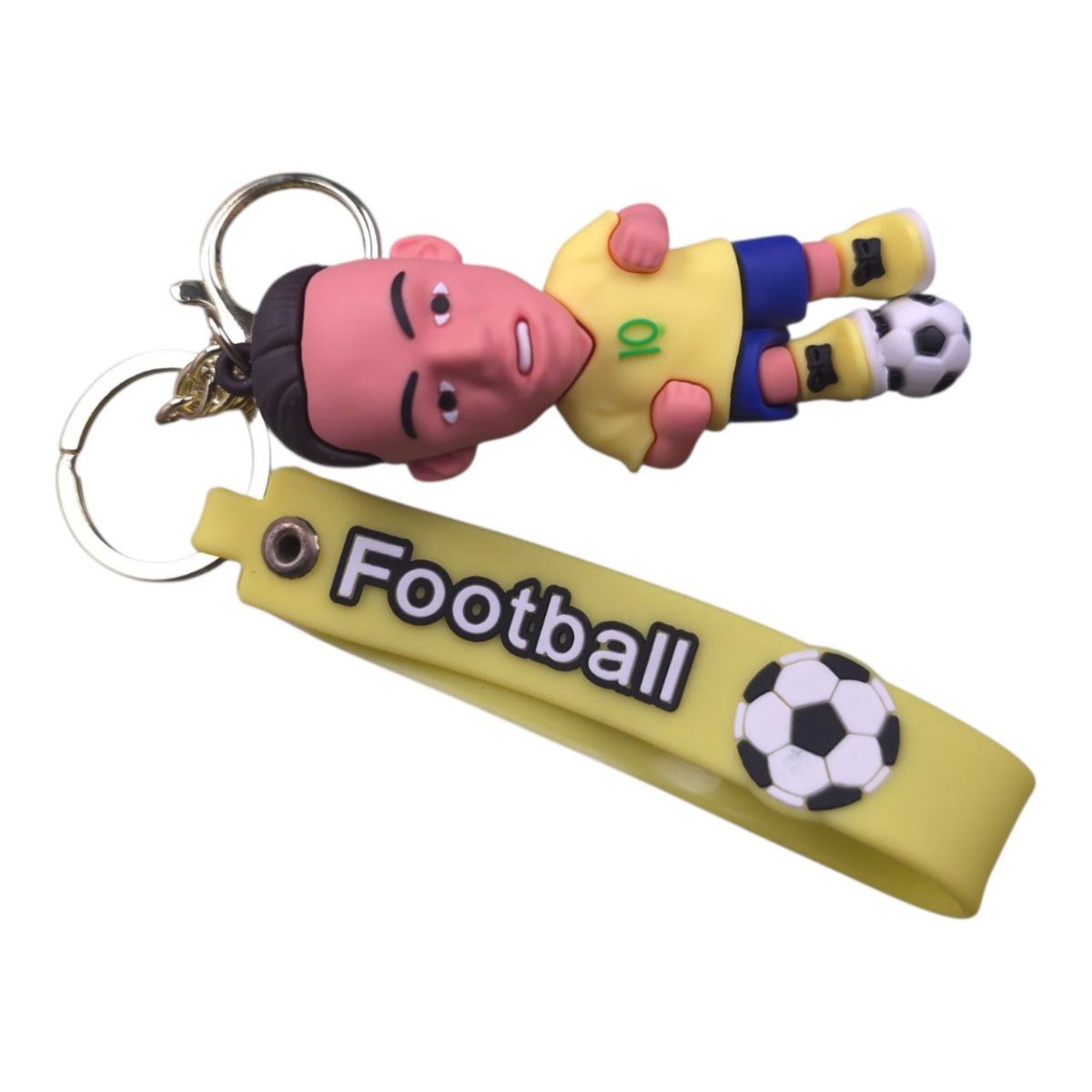 Cartoon soccer player keychain: yellow jersey, blue shorts, lying pose, with a yellow strap reading 'Football' and a soccer ball graphic on the end.