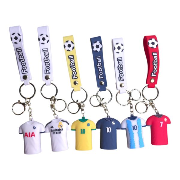 Six soccer-themed keychains featuring colored straps with a football (soccer ball) charm and a miniature team jersey charm at the bottom.