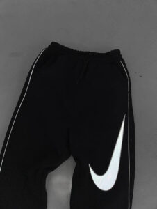 586851525_17891230272372975_8659930914686813461_n | UAE SPORT STORE Black Nike sweatpants with a large white swoosh logo on the leg, photographed on a gray background