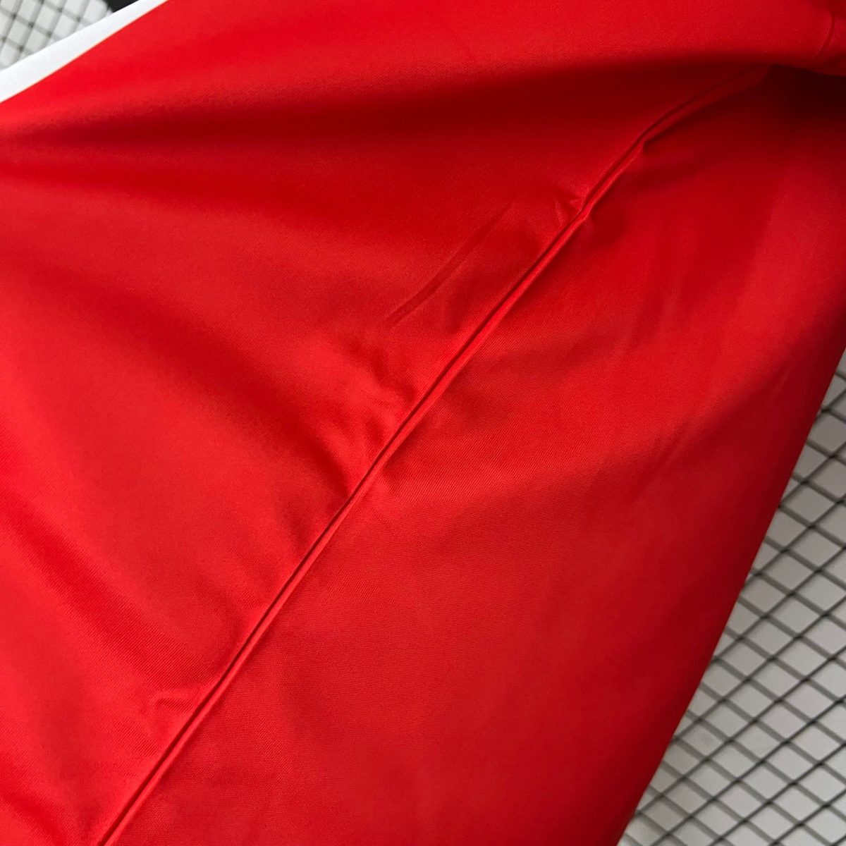 Close-up of bright red fabric with a diagonal seam, likely upholstery.