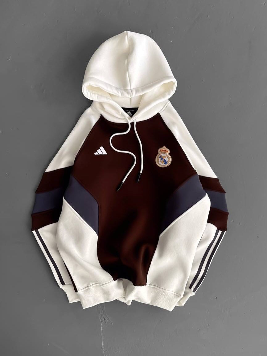 587218937_18541949011001666_1991613191177854560_n Real Madrid Adidas hoodie with white sleeves and hood, burgundy chest with navy panels, crest on the left chest, white drawstrings.