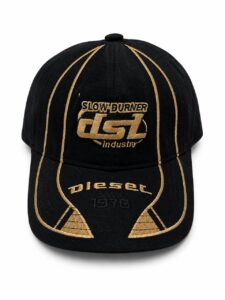Black baseball cap with gold embroidery, features 'SLOW BURNER' logo and 'DIESEL since 1978' on the brim and crown.