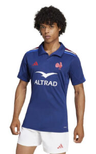 Male model wearing a blue rugby polo with ALTRAD logo and French rooster crest, paired with white shorts.