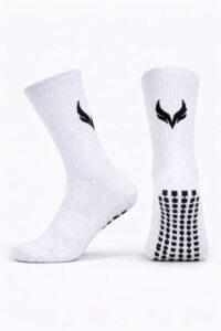 5967537890642300084 | UAE SPORT STORE Pair of white athletic socks standing upright, with black logo near the top and dotted grip pattern on the sole.