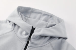 Close-up of a light gray zip-up hoodie collar with black zipper slightly open.