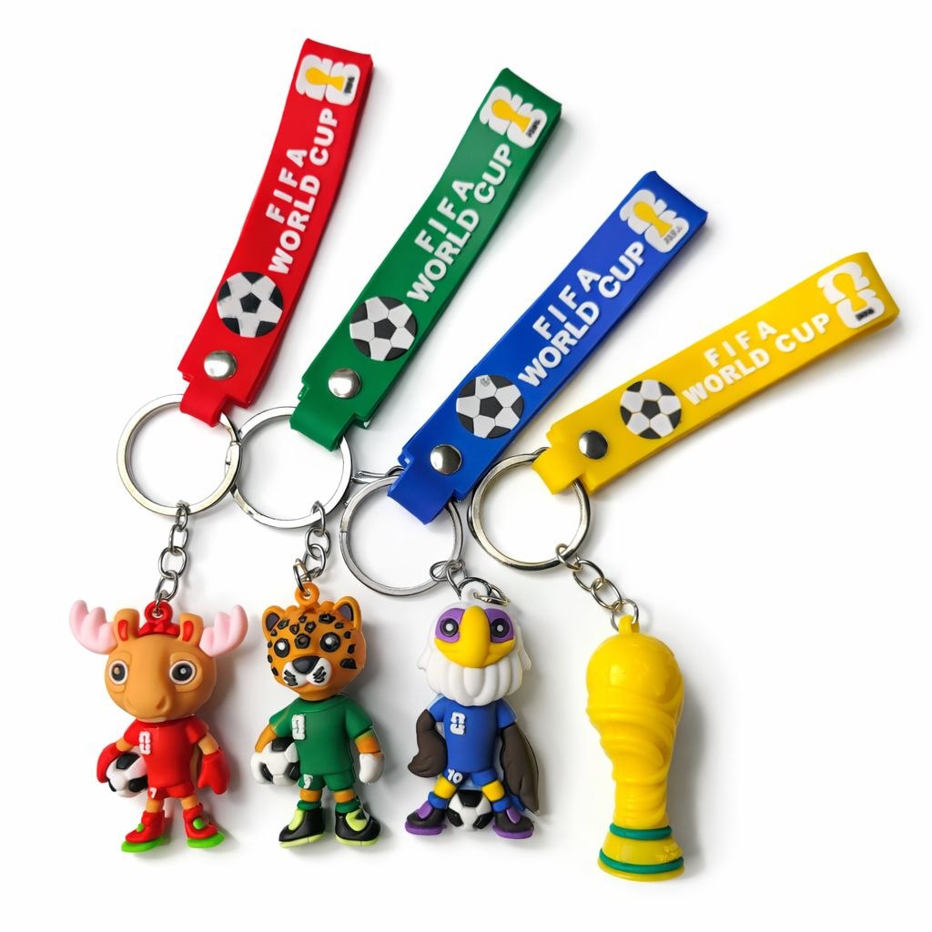 5987635966765632789 FIFA World Cup keychains: four colorful lanyards (red, green, blue, yellow) with soccer-ball charms and cartoon mascot figures, plus a yellow trophy charm.
