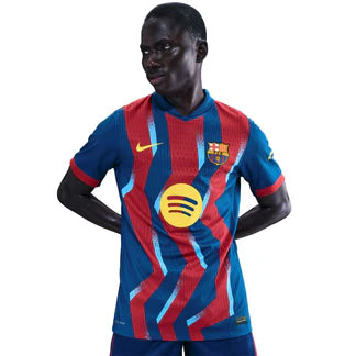 Male soccer player in a blue and red Barcelona jersey with the Spotify logo on the chest, standing with hands on hips.