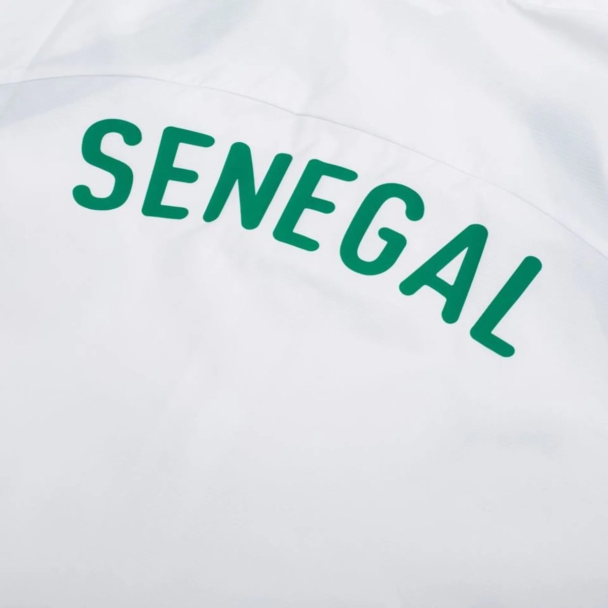 Close-up of a white fabric or bag with partial bold green text reading 'SENEGAL'.