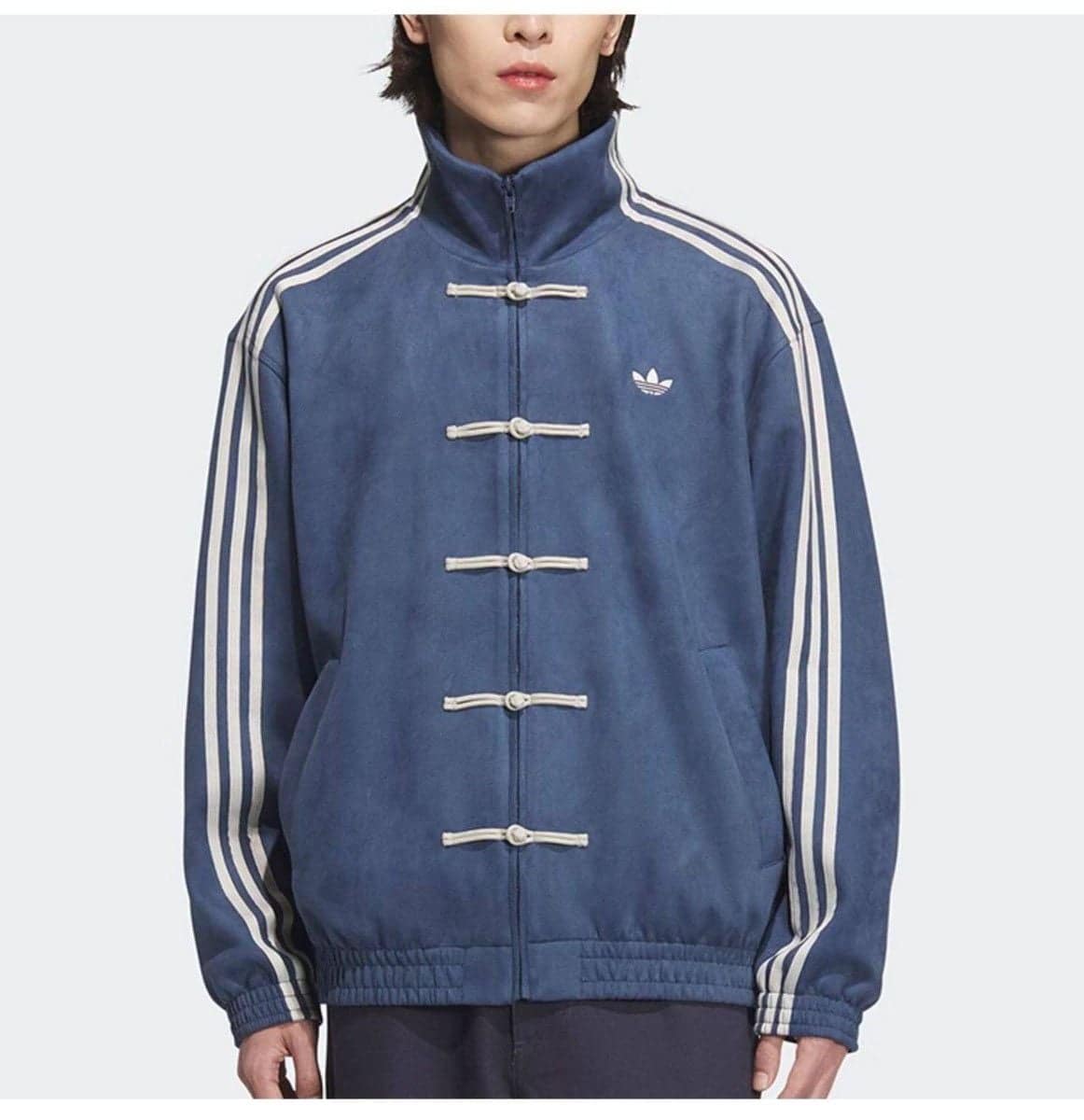 5c85b47e-872f-44a9-b02d-270ca41abdb6 | UAE SPORT STORE Man wearing a blue Adidas track jacket with white stripes along the sleeves and toggle closures on the front.
