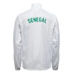 Back view of a white jacket with green curved text 'SENEGAL' across the upper back. Readable on a clean white garment.