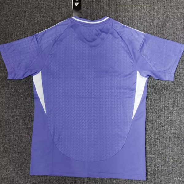 Purple athletic jersey hanging on a display hook with white side panels visible against a dark carpeted background, showing the back side and collar details.