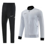 Nike men's athletic track pants in black with white swoosh and matching light gray zip-up jacket with black cuffs—product set