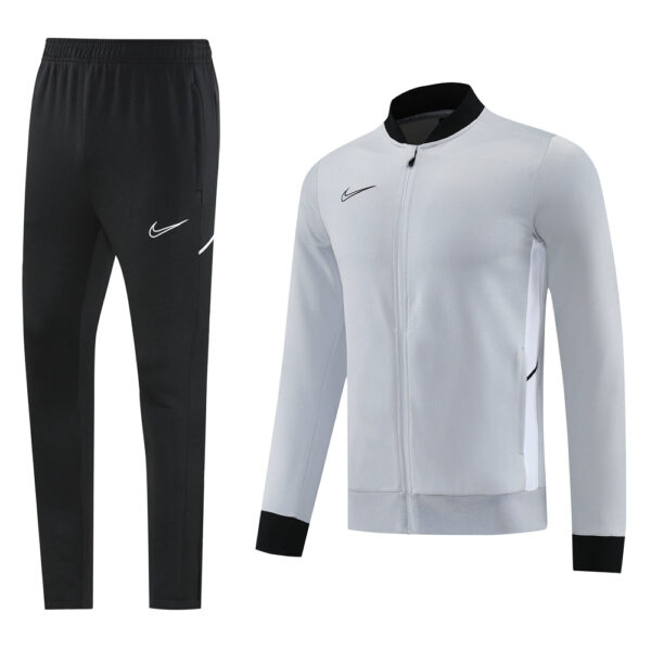 Nike men's athletic track pants in black with white swoosh and matching light gray zip-up jacket with black cuffs—product set