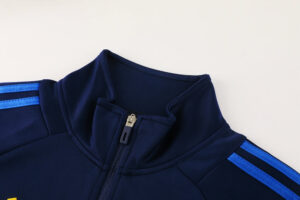 5dde53c2 | UAE SPORT STORE Dark navy jacket with a front zipper and light blue stripe detailing along the shoulders, close-up collar view, sport style.