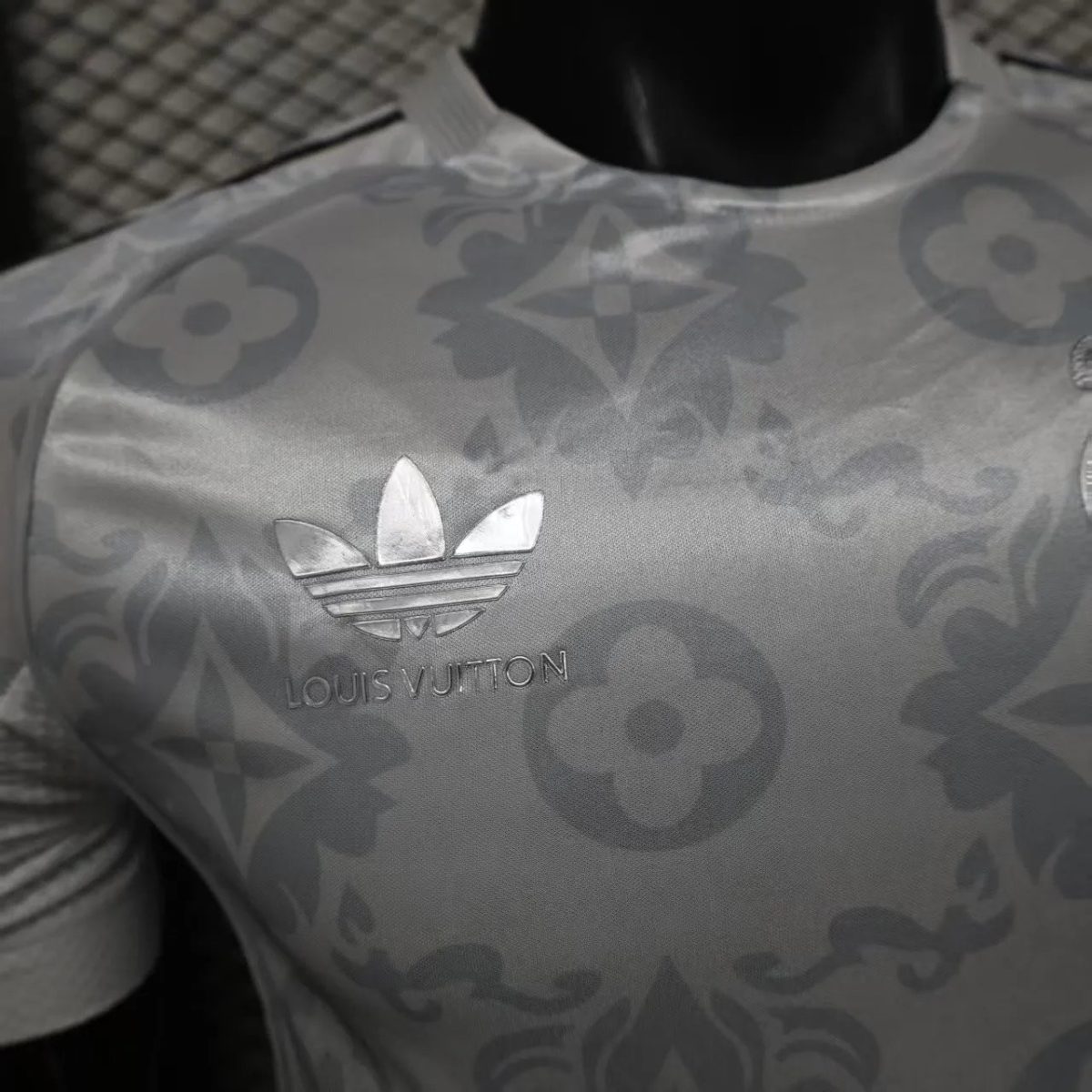 Close-up of light-patterned fabric with a Louis Vuitton logo and monogram pattern visible on the chest area.