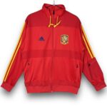 Red Adidas Spain jacket with yellow sleeve stripes, crest on the left chest, and zip front (front view).
