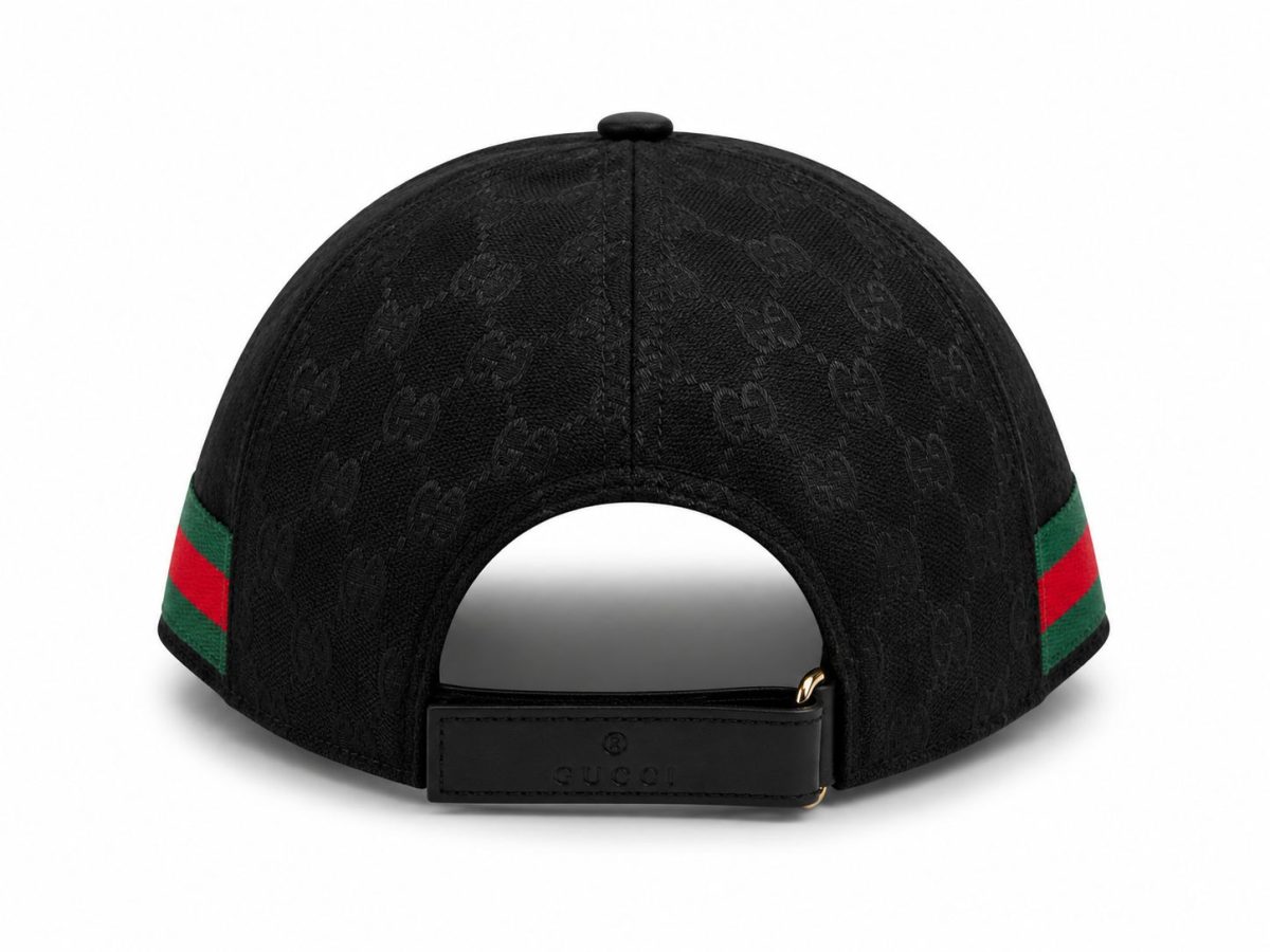 Back view of a black Gucci cap with a repeating monogram pattern and an adjustable strap featuring a Gucci logo. The sides have green-red-green stripes.
