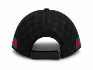 Back view of a black Gucci cap with a repeating monogram pattern and an adjustable strap featuring a Gucci logo. The sides have green-red-green stripes.