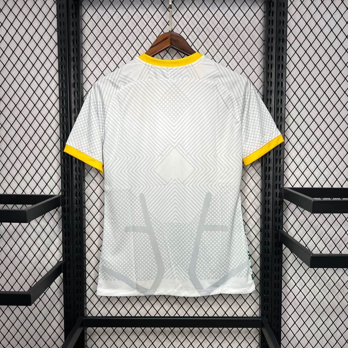 Light gray geometric-patterned shirt on a wooden hanger with yellow collar and sleeve trim, hung on a metal rack.